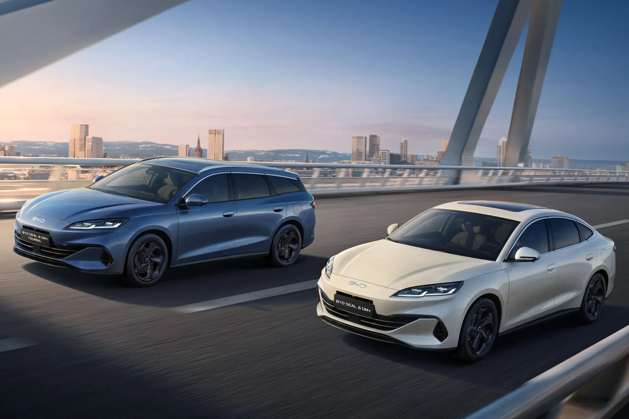 BYD Seal 6 sedan in white and Touring wagon in blue driving on bridge