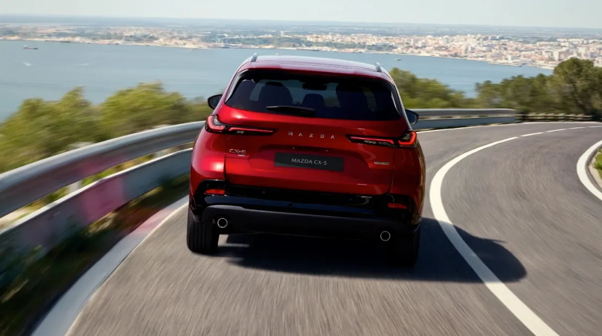 2026 Mazda CX-5 rear view driving on coastal road