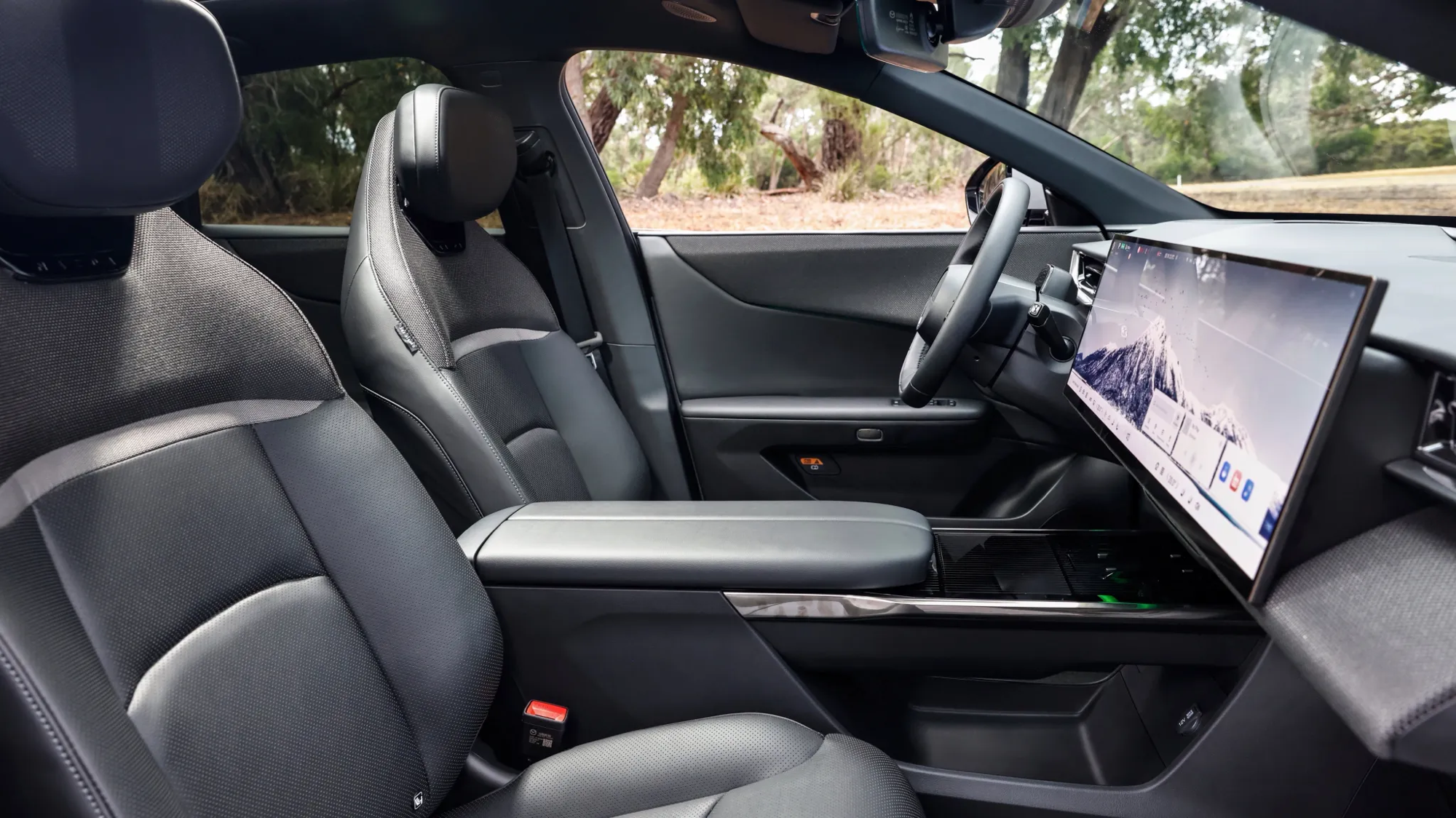 Mazda CX-6e driver's seat showing leather seats, centre console, and widescreen display