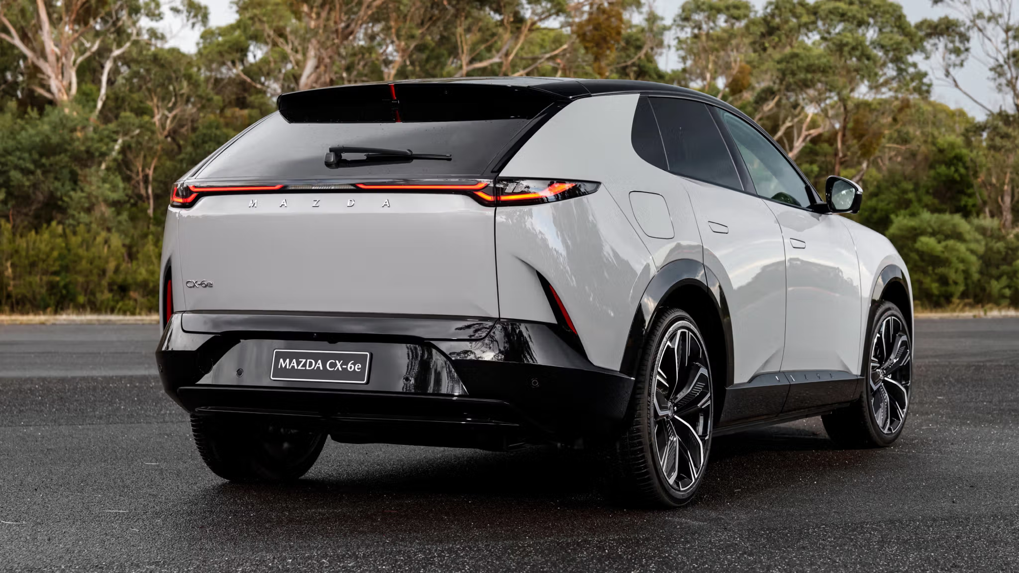 Mazda CX-6e rear three-quarter view showing full-width tail light bar